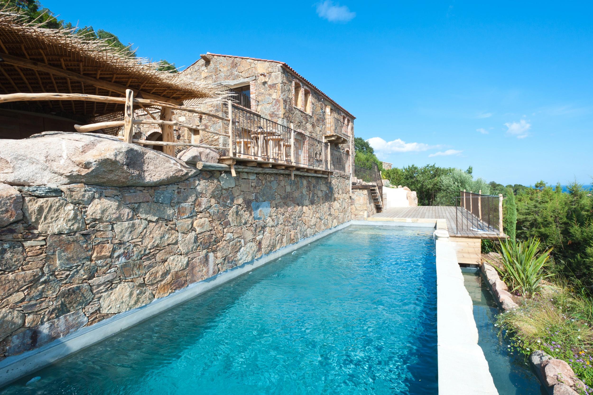 Piscine au bord d'une maison en pierre aux Oliviers de Palombaggia en Corse-du-Sud.