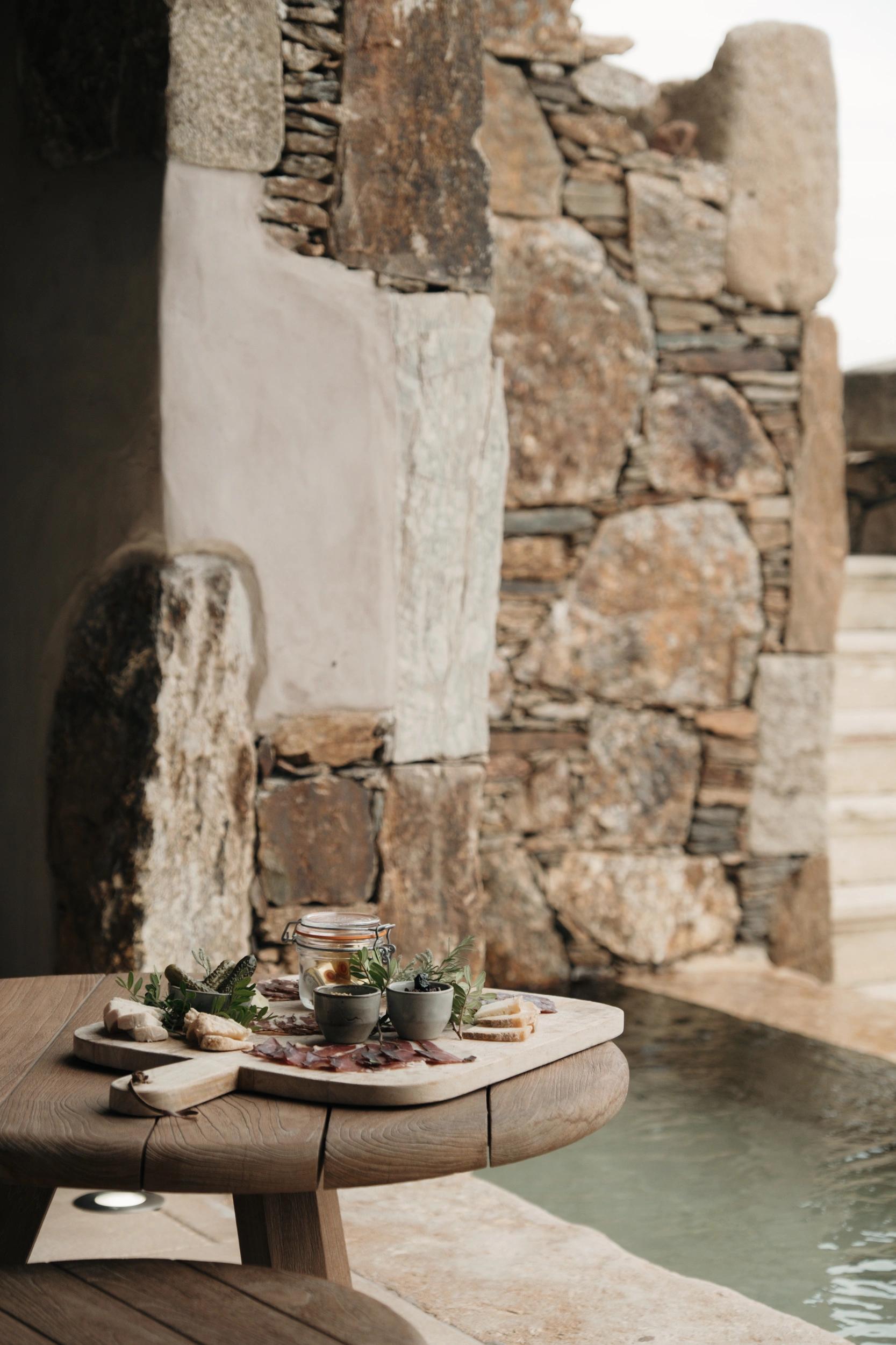 Apéro au bord d'une piscine en pierre aux Oliviers de Palombaggia en Corse-du-Sud.