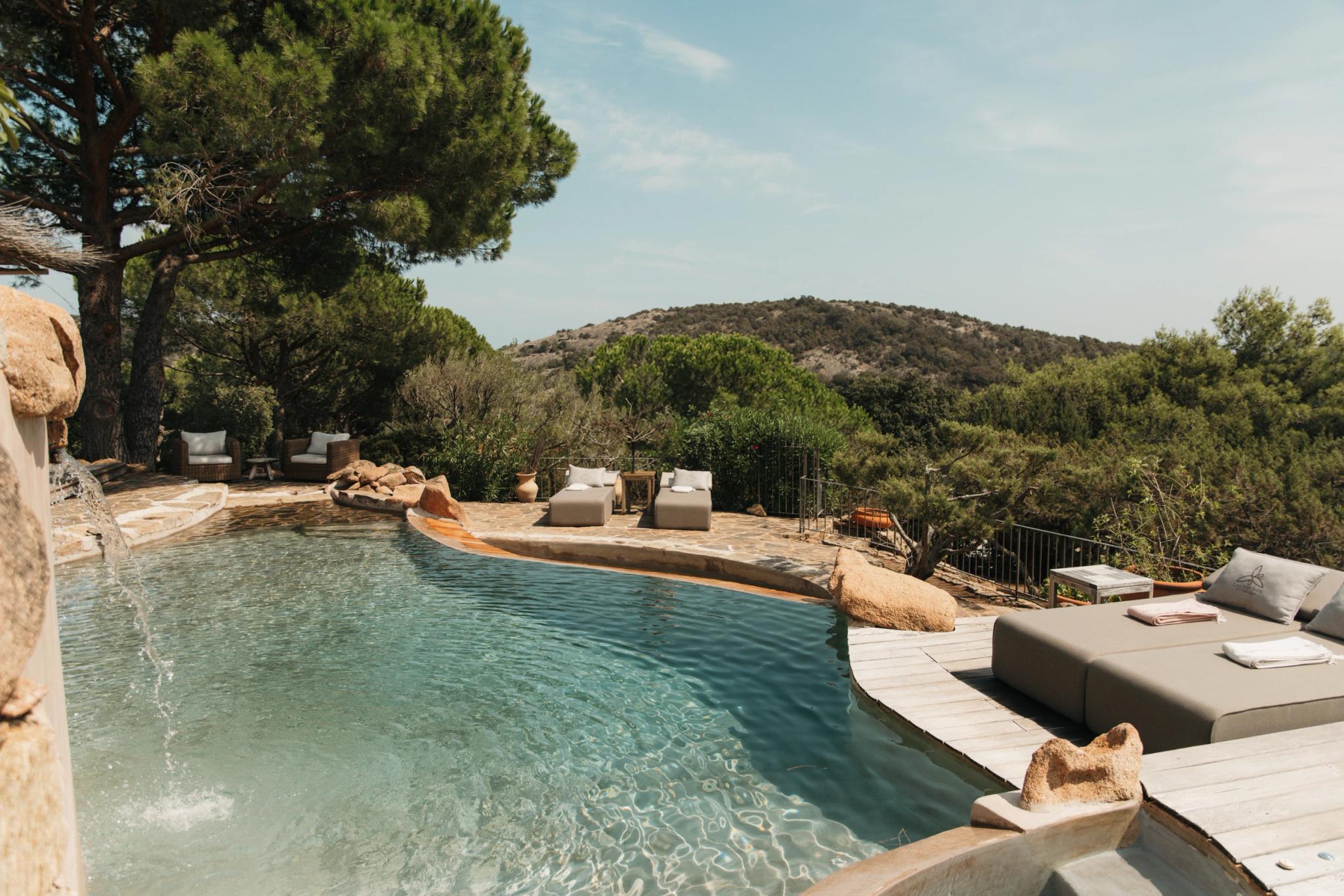 Piscine avec transats au milieu d'espaces verts aux Oliviers de Palombaggia en Corse-du-Sud.